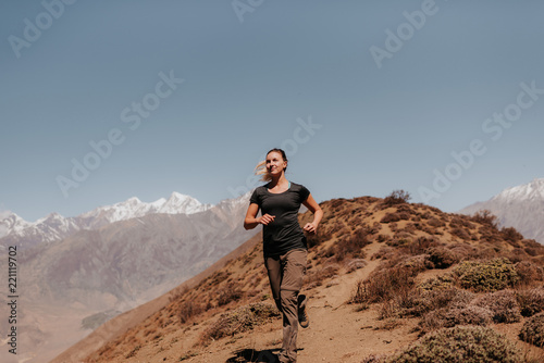 Woman jogging down from peak, Annapurna Circuit, the Himalayas, Muktinath, Nepal