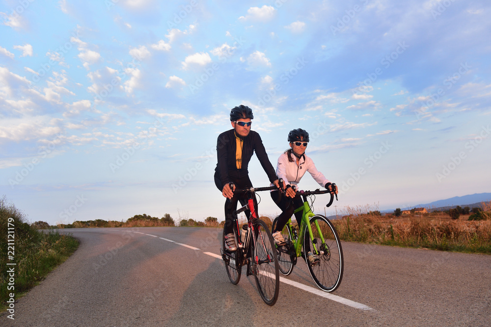 a couple of cyclists stopped on the road a couple of cyclists stopped on the road