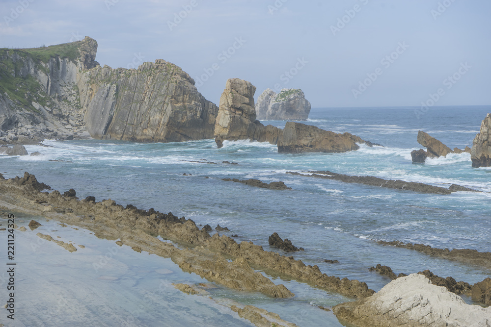 Rocks on the beach. Dramatic view of Playa de la Arnia, rocky coastline in Santander ,Cantabria, Spain.