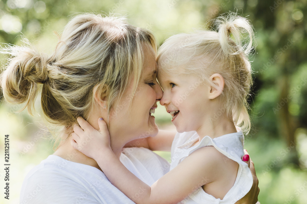 Happy mother cuddling her daughter in nature Happy mother cuddling her daughter in nature