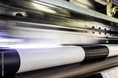 Photos Massive print head flashing by while processing a big oversized roll of glossy premium paper in a professional plot and print facility