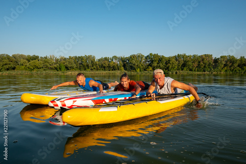 Joyful friends, a SUP surfers relax on the big river © sanechka