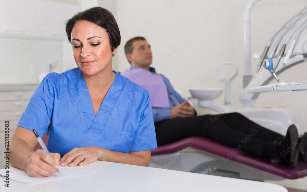 Obraz premium dentist in uniform writing document