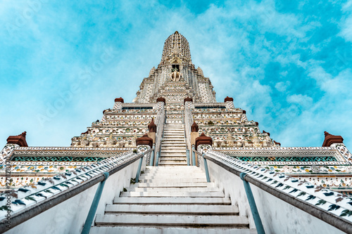 Wat Arun buddhist temple with stairs in foreground during bright sunny day and blue sky  Bangkok  Thailand