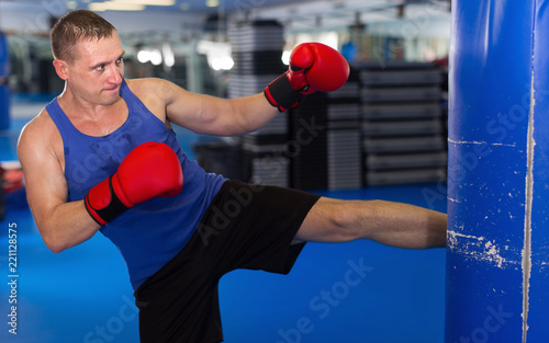 Adult active man is training with punching bag