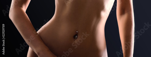 Crop photo of perfect female body. Navel piercing photo