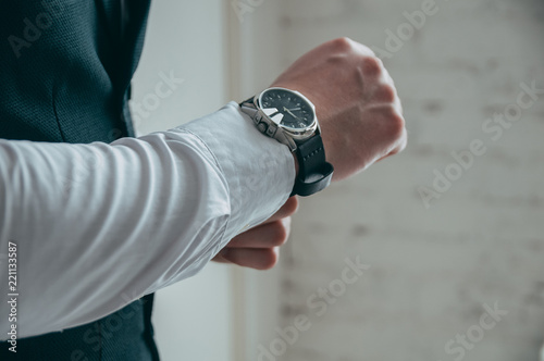 Man looking at luxury watch. The groom's wedding day.