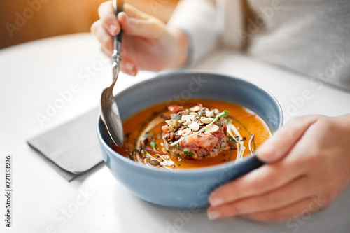Fotografie food, new nordic cuisine and people concept - woman eating vegetable pumpkin-gin