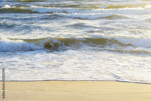 Wavy sea and sandy seashore in summer.