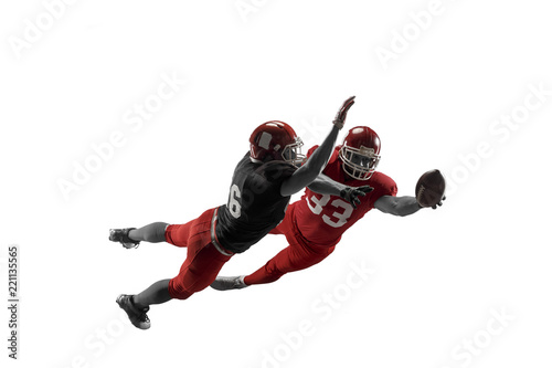 Active two american football player isolated on white background. Fit caucasian men in uniform with ball jumping over studio background in jump or motion. Human emotions and facial expressions concept
