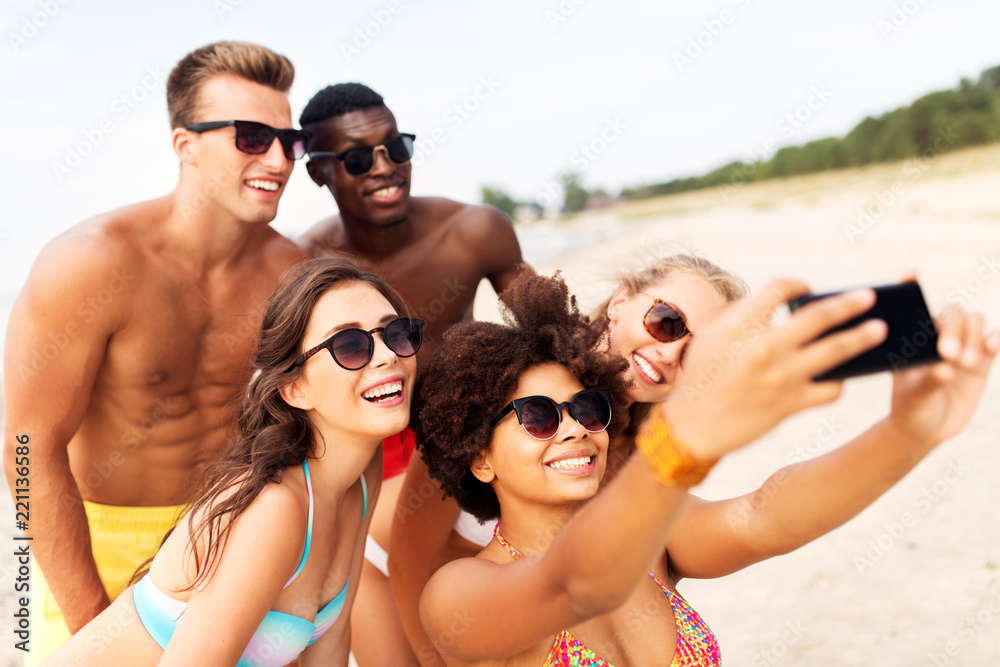 friendship, summer holidays and people concept - group of happy friends taking picture by smartphone on beach friendship, summer holidays and people concept - group of happy friends taking picture by smartphone on beach