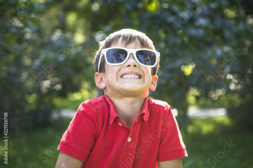 Happy smiling  child boy in sunglasses playing outdoor.