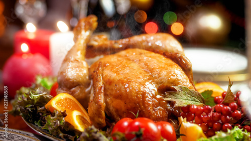 Hot baked chicken from oven on family festive dinner table on Christmas eve photo