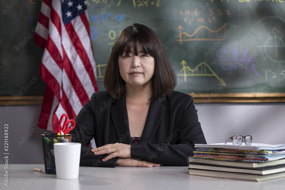 Fototapeta premium Portrait of a teacher at her desk in a classroom