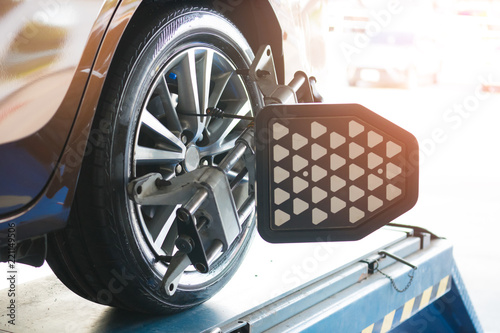 Closed up of an auto wheel that is undergoing wheel alignment with computerized. Stand balancing tire wheel machine. Tyre assembling. Tire balance - Car service concept