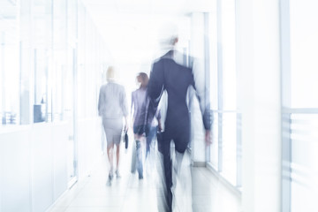 group of young business people are actively moving around the large office