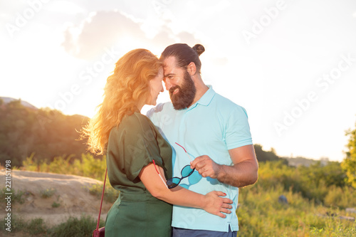 Happy adult couple is a man and a woman over 40 years of age. Beautiful lovers in nature in the rays of sunset of the sun.