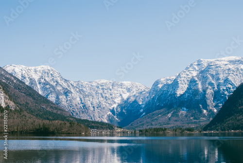 Beautiful Alpine mountains on the other side of the lake near Hallstatt. White summits beneath blue skies. View from the lakeside © Yurii Zymovin