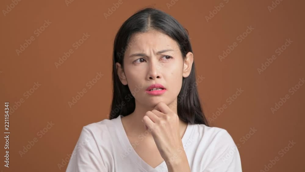 Thinking woman isolated. Portrait of asian woman in white t-shirt thinking hard and excited to find a solution, looking at camera. Thinking woman isolated. Portrait of asian woman in white t-shirt thinking hard and excited to find a solution, looking at camera.