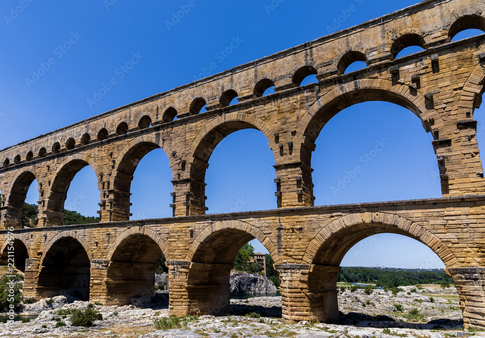 Pont du Gard (bridge across Gard) ancient Roman aqueduct across Gardon River at sunny day in  Provence, France