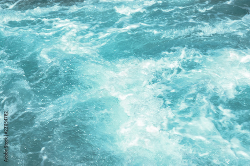 Troubled aqua blue sea water with white foam, abstract nature background concept