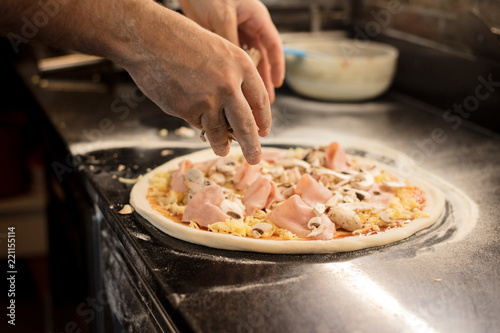 Skilled chef preparing pizza rolling with hands