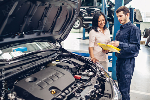 Car service center scene. The mechanic communicates with the client