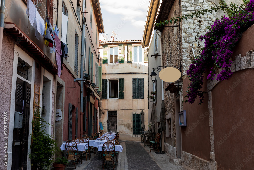 cozy narrow street with traditional houses and outdoor cafe in provence, france