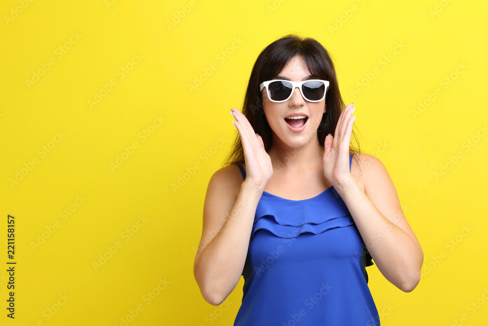 Fototapeta premium Young woman with sunglasses on yellow background