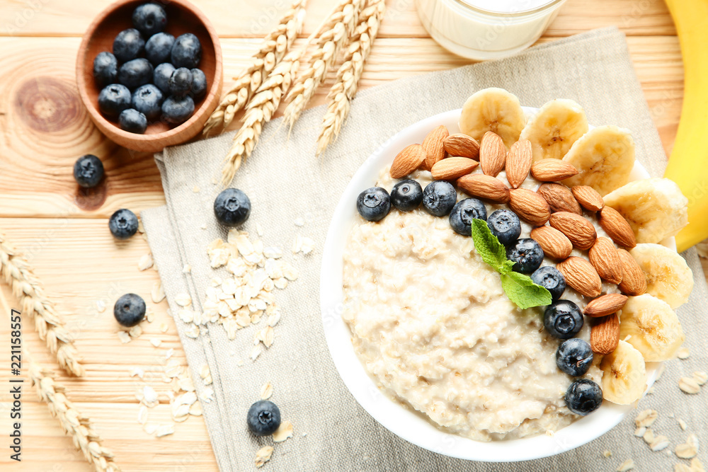 Oatmeal with berries and nuts in bowl on wooden table Oatmeal with berries and nuts in bowl on wooden table