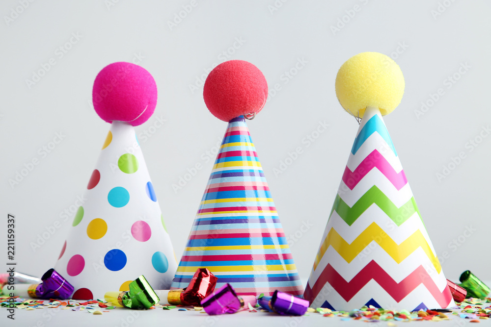 Obraz premium Birthday paper caps with blowers and confetti on grey background