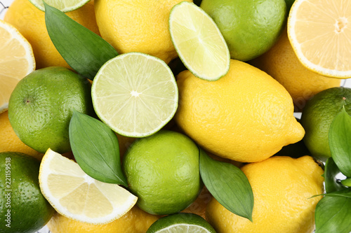 Background of lemons and limes with green leafs