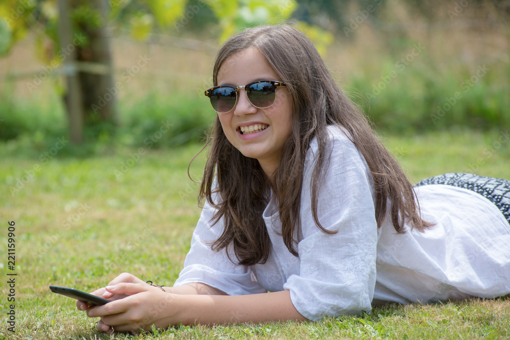 beautiful young girl with sunglasses is using the smartphone beautiful young girl with sunglasses is using the smartphone