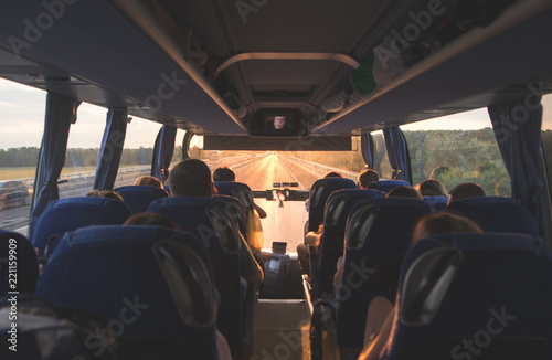 Bus with people going on the road in the evening at sunset. Photo interior of the bus. Background. Bus tourists