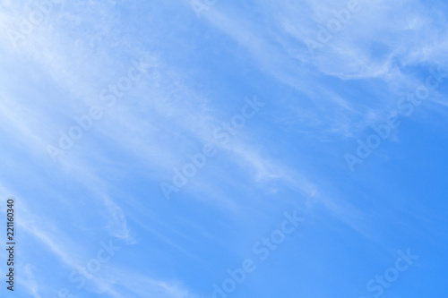 White feather clouds in bright azure sky as background
