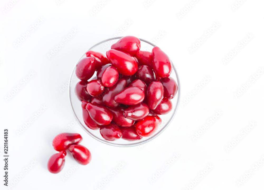 Berries are cornelian in a glass jar on a white background. Harvest, Autumn, Vegetarianism Berries are cornelian in a glass jar on a white background. Harvest, Autumn, Vegetarianism