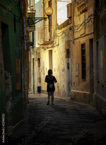 Woman walks on a small street in a small village