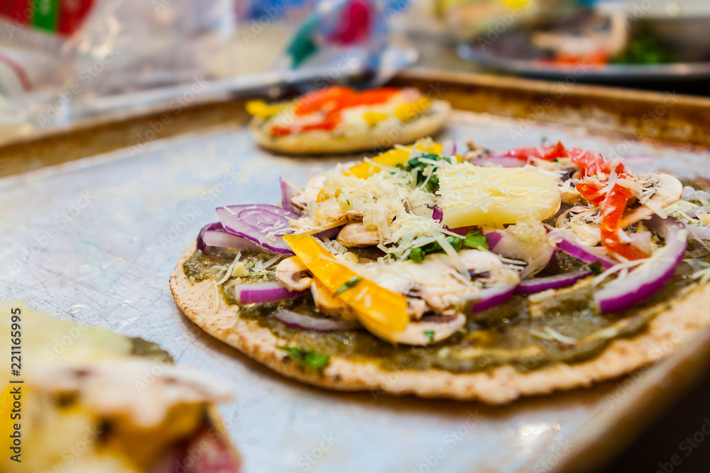 Individual Vegetarian Flatbread Pizzas on a Tray Ready to Be Baked Individual Vegetarian Flatbread Pizzas on a Tray Ready to Be Baked