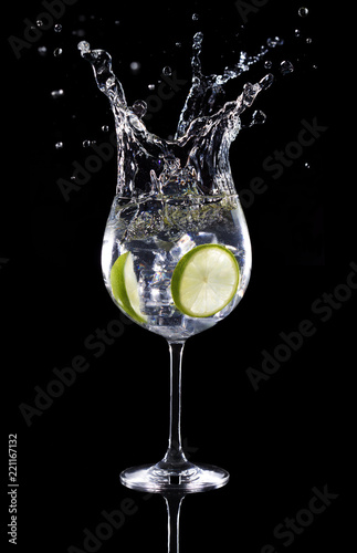 gin tonic cocktail splashing isolated on black background