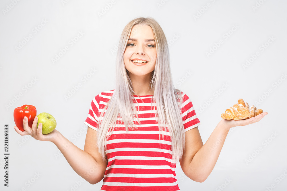 Portrait of beautiful young blonde woman choosing between a healthy and unhealthy food. Isolated over white background. Portrait of beautiful young blonde woman choosing between a healthy and unhealthy food. Isolated over white background.