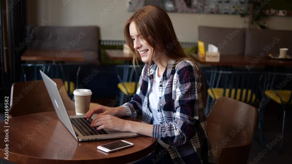Beautiful girl is working at the computer and talking on the phone Beautiful girl is working at the computer and talking on the phone
