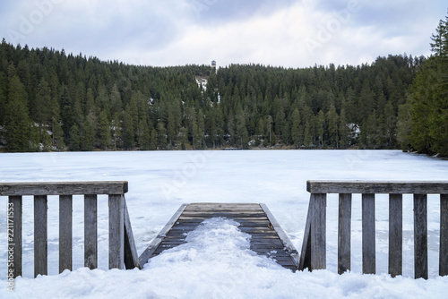 Small wooden pier and fence over a frozen lake © YesPhotographers