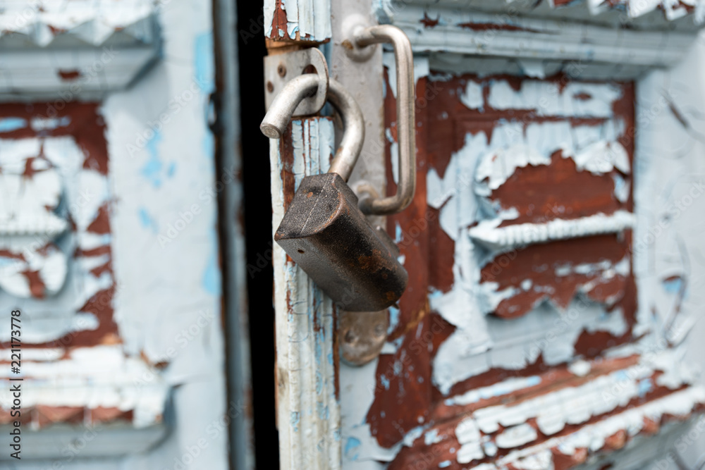 Close-up keyholes with curtains and a handle on the blue many times painted cracked double-barreled wooden vintage door of the last century with a post slit. Close-up keyholes with curtains and a handle on the blue many times painted cracked double-barreled wooden vintage door of the last century with a post slit.
