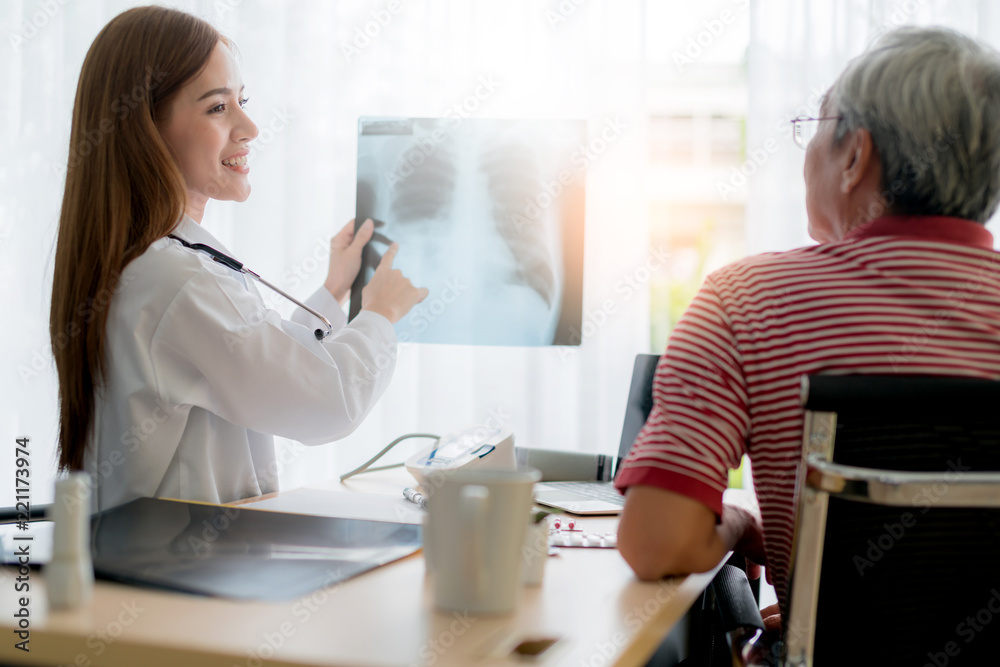Obraz premium asian woman doctor consult and examine x-ray result with senior patient with care and focus