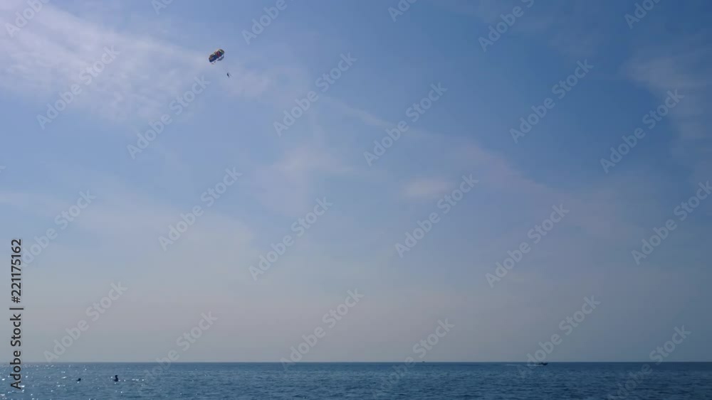 Powerboat pulls a parachute in the sky. Parasailing in clear sunny weather. Marine entertainment. Active entertainment in the resort Powerboat pulls a parachute in the sky. Parasailing in clear sunny weather. Marine entertainment. Active entertainment in the resort