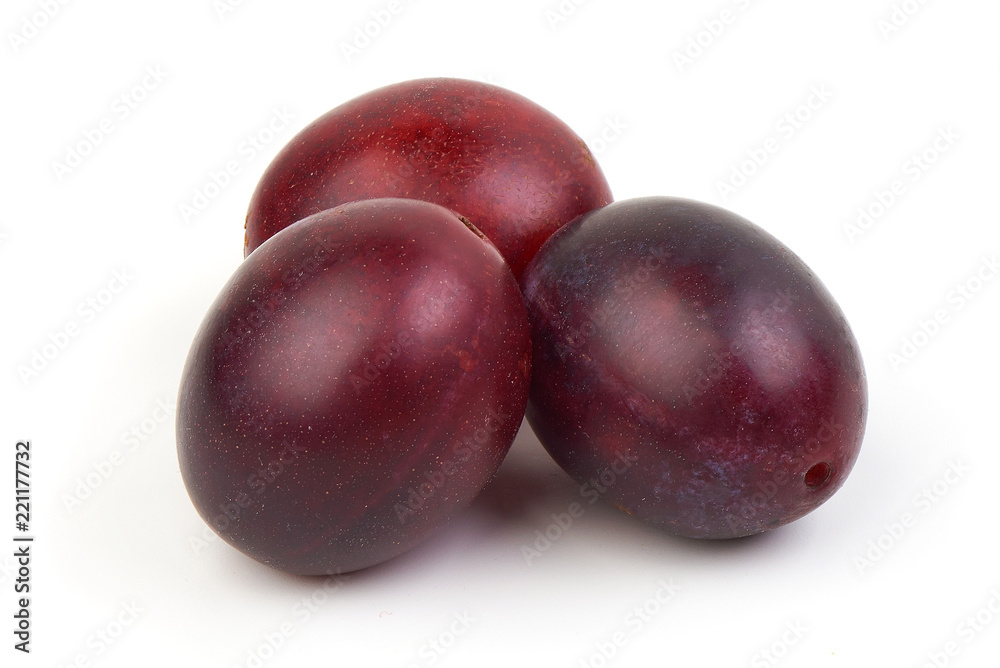 Fresh juicy ripe plums with leaves isolated on white background.