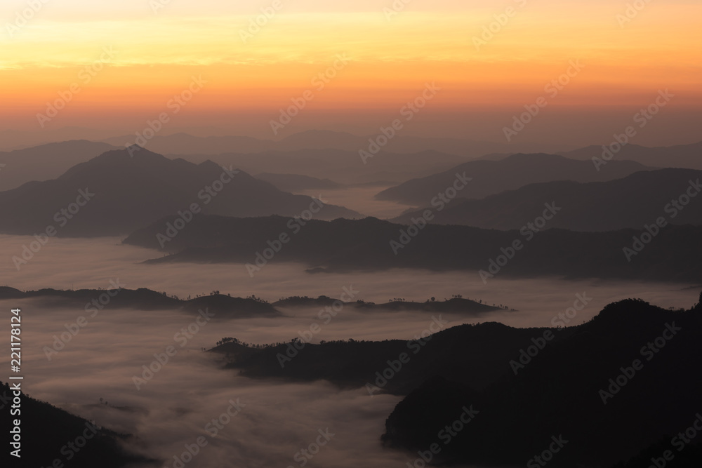 Fog among mountainn, yellow gradient sky at dawn