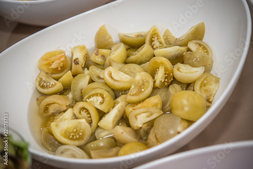 Canned green tomatoes, cut into pieces in plate