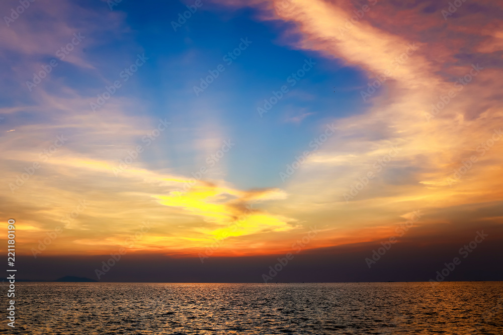Vivid twilight sunset sky and motion blur of the sea under with long exposure effect.Beautiful golden sunset in the sea with saturated sky and clouds. Vivid twilight sunset sky and motion blur of the sea under with long exposure effect.Beautiful golden sunset in the sea with saturated sky and clouds.