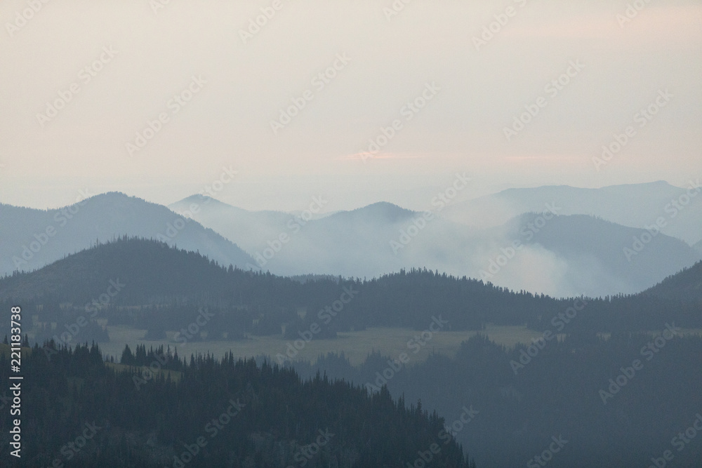 Mountains with trees, clouds and haze